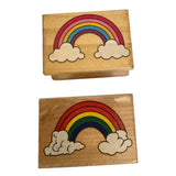 Two wooden stamps with rainbow and cloud designs on a white background