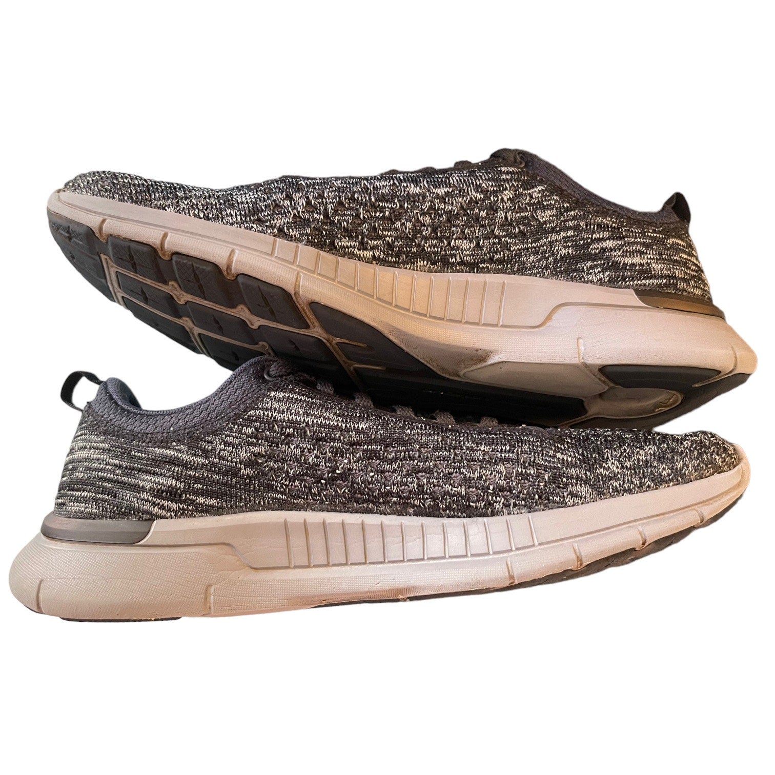 Side of a pair of gray running shoes on a white background