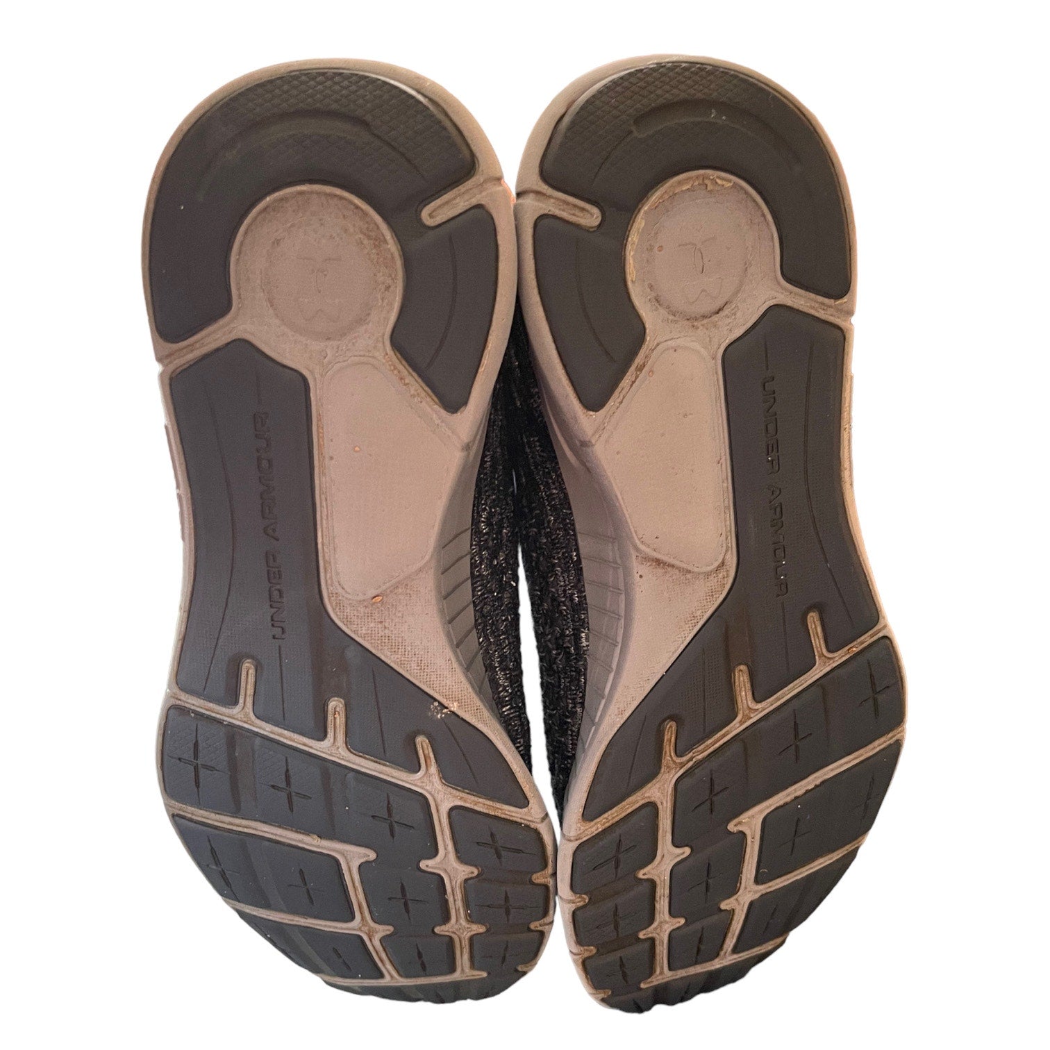 Bottoms of gray running shoe soles on a white background