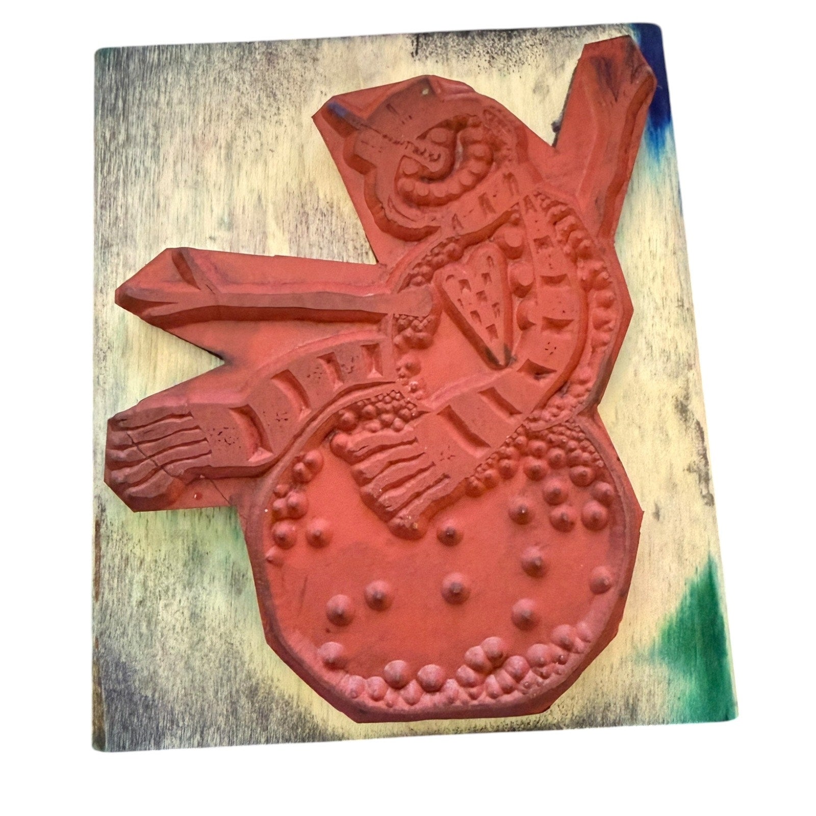 Red decorative rubber stamp on a wooden block with a white background