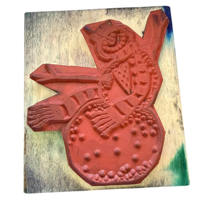 Red decorative rubber stamp on a wooden block with a white background