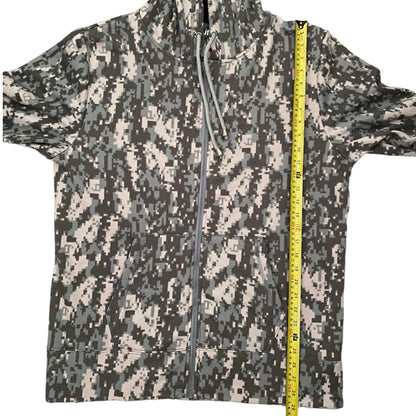 A zip-up hoodie with a digital camouflage pattern, shown flat with a yellow tape measure standing vertically on the right side for scale.