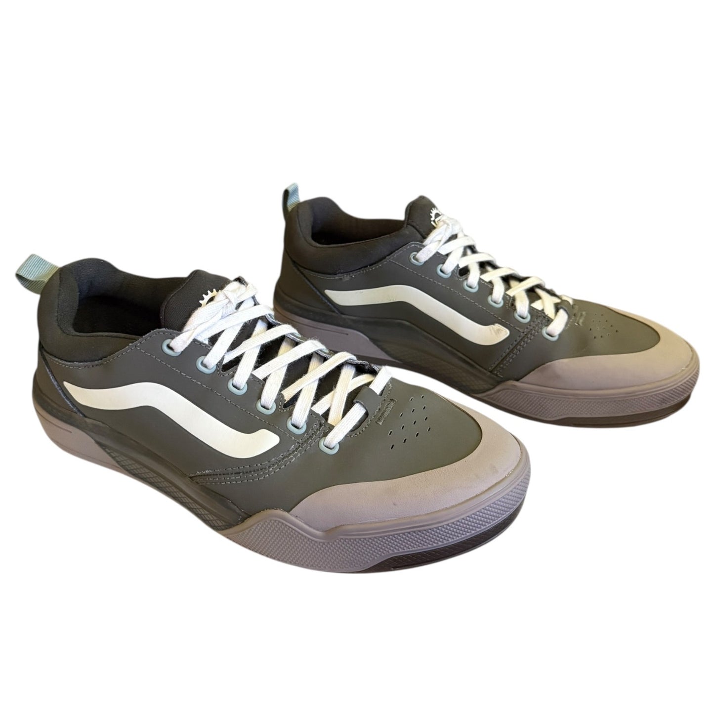 Front side of Pair of green sneakers with white accents on a white background