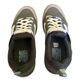 Top of a Pair of green sneakers with white laces on a white background