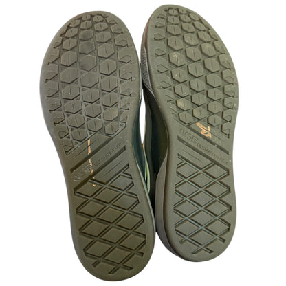 Close-up of the soles of a pair of shoes with a brand logo on a white background