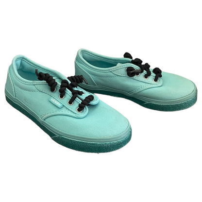 Pair of green sneakers with black laces on a white background