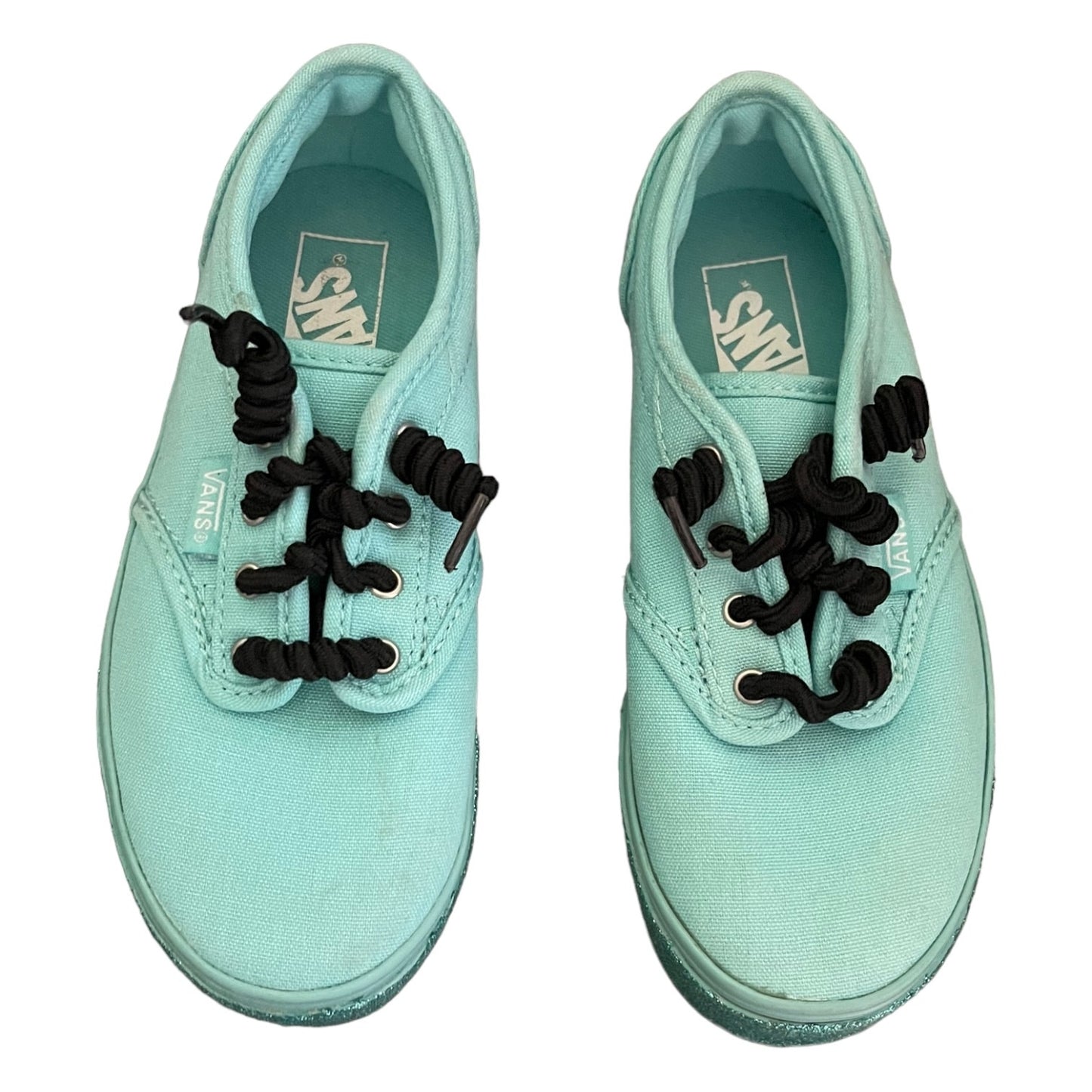 Top view of green sneakers with black laces on a white background