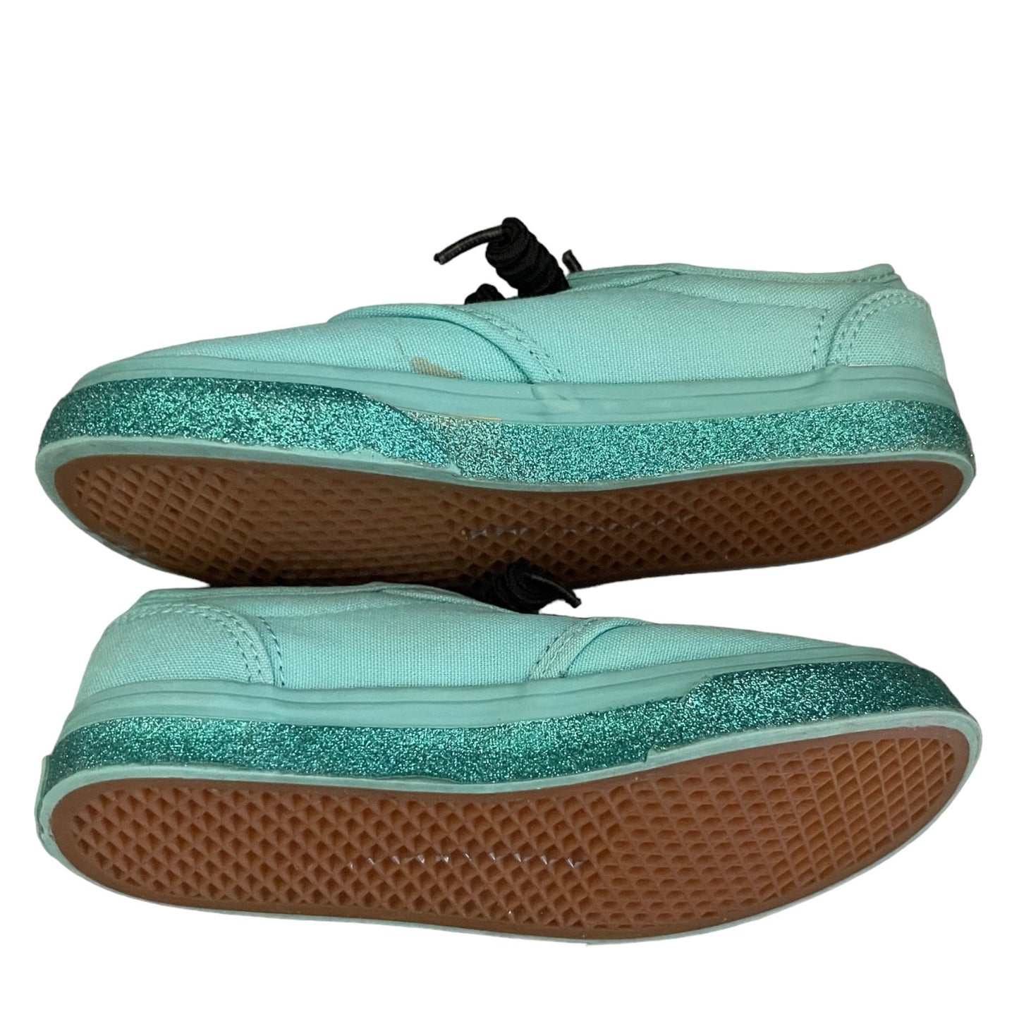 Side view of green sneakers with glittery green sole on a white background