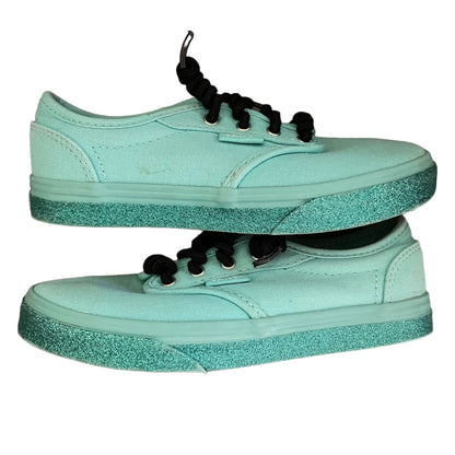 Side view of green sneakers with glittery sole on a white background