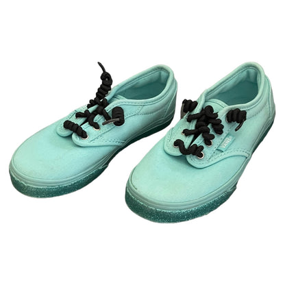 Side view Pair of green sneakers with black laces on a white background