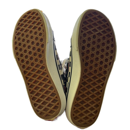A pair of classic Vans sneakers shown from the sole view, displaying the brown waffle-patterned rubber outsoles against a white background.