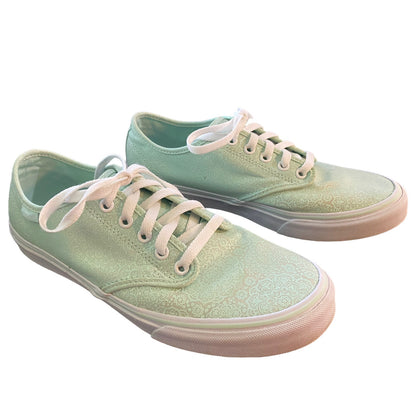 Front side of Pair of light green sneakers with white laces on a white background
