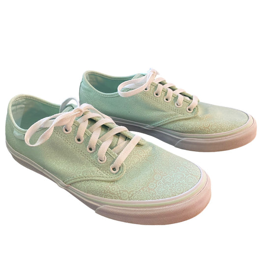 Front side of Pair of light green sneakers with white laces on a white background