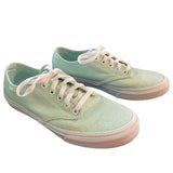 Front side of Pair of light green sneakers with white laces on a white background