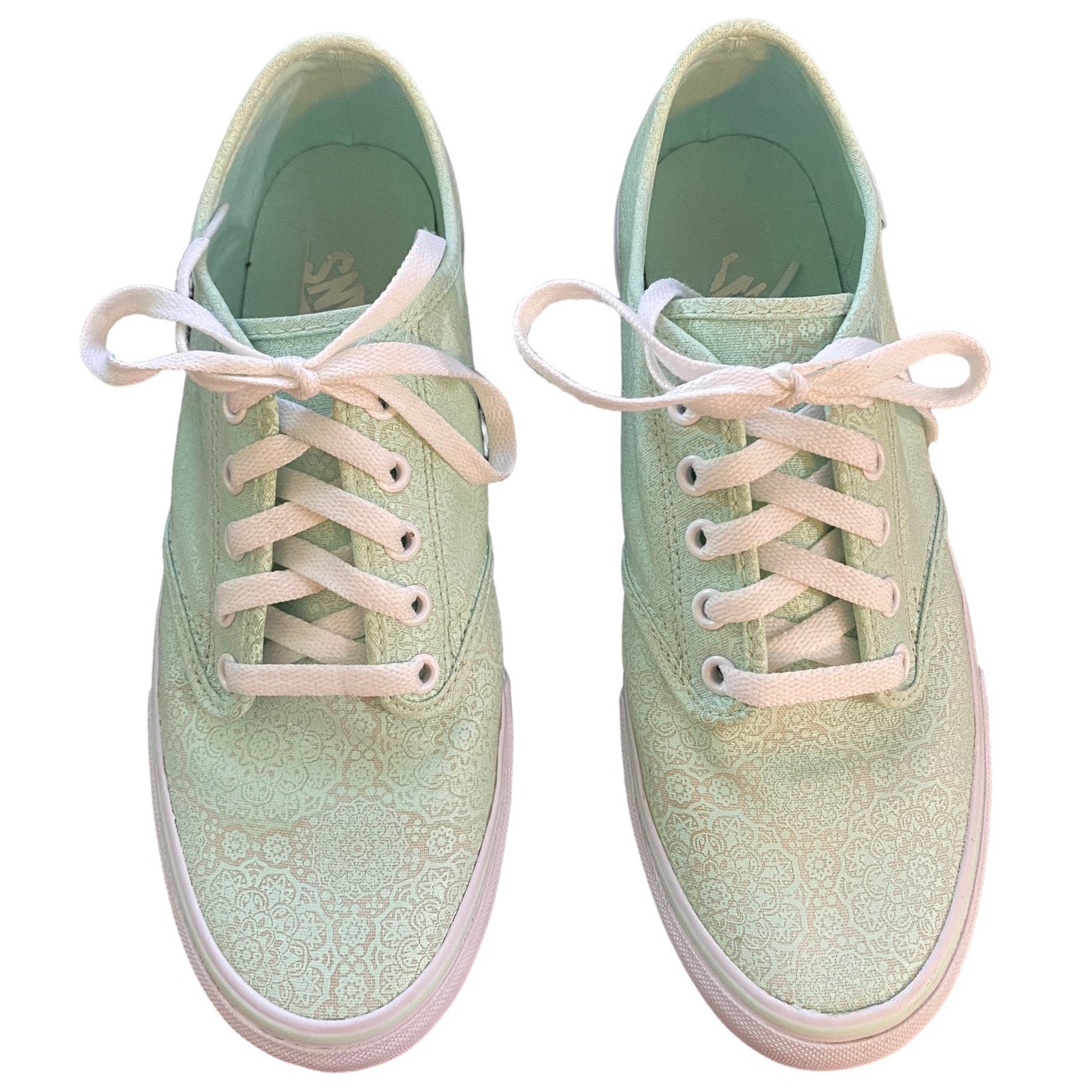 Front of a Pair of light green sneakers with white laces on a white background