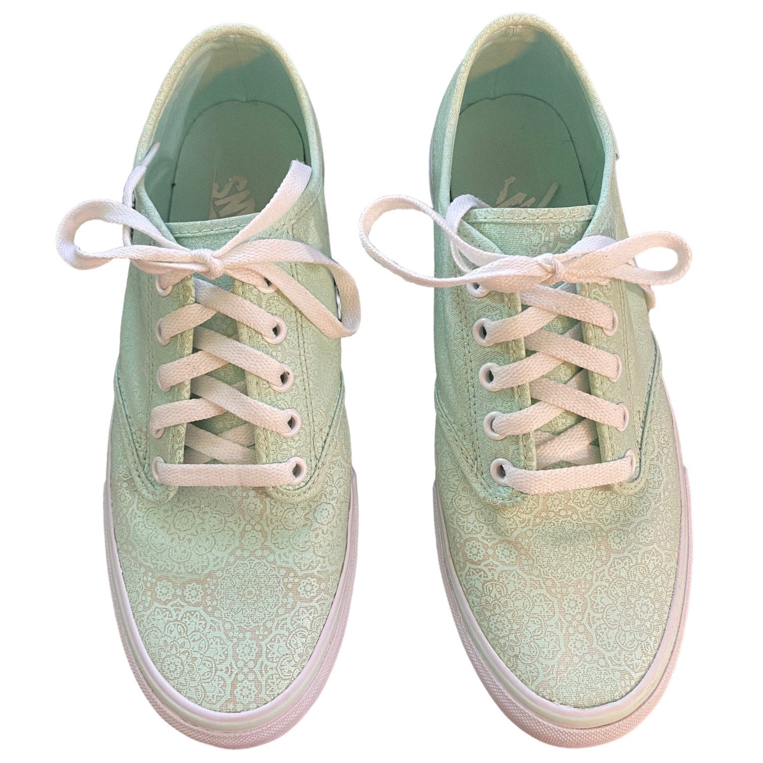 Front of a Pair of light green sneakers with white laces on a white background