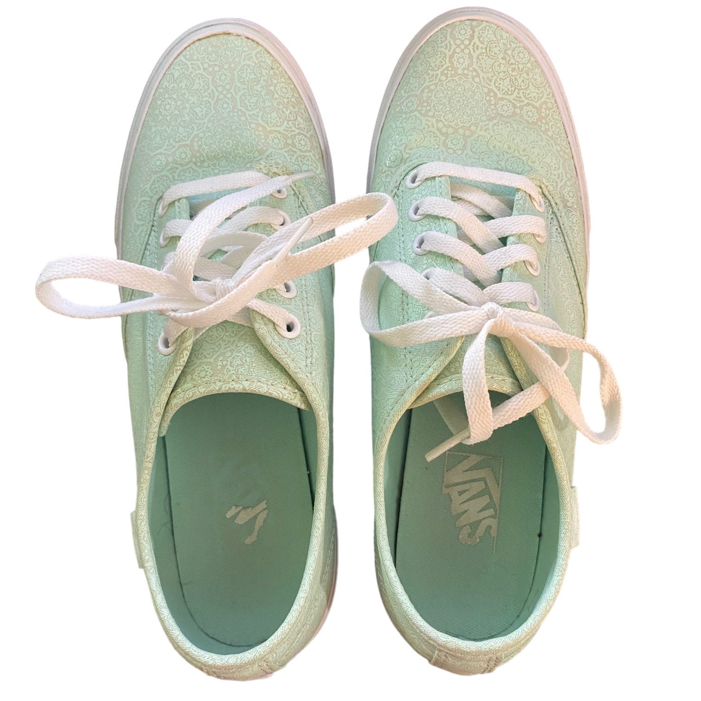 Top view of a Pair of light green sneakers with white laces on a white background