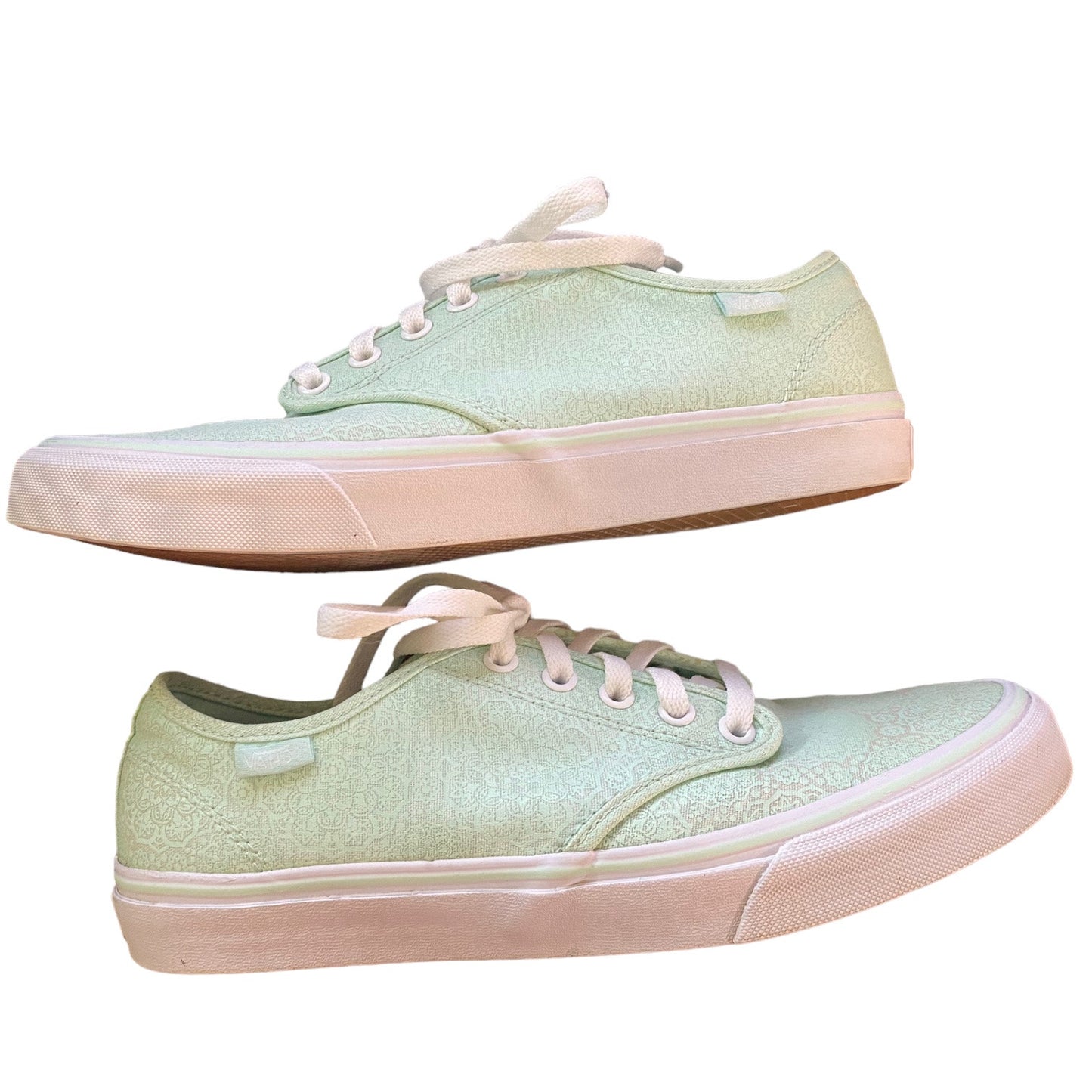 Side of a Pair of light green sneakers with white laces on a white background