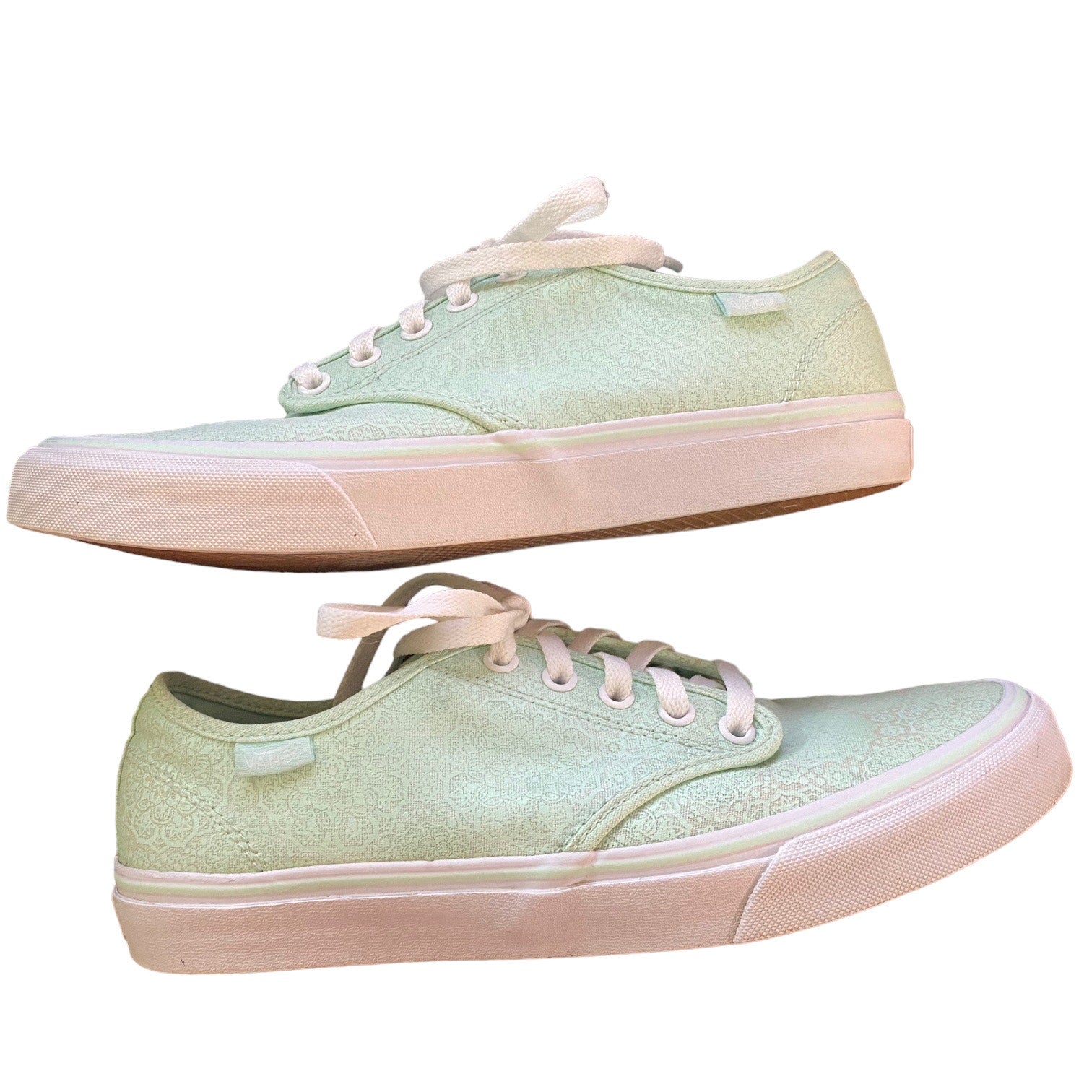Side of a Pair of light green sneakers with white laces on a white background