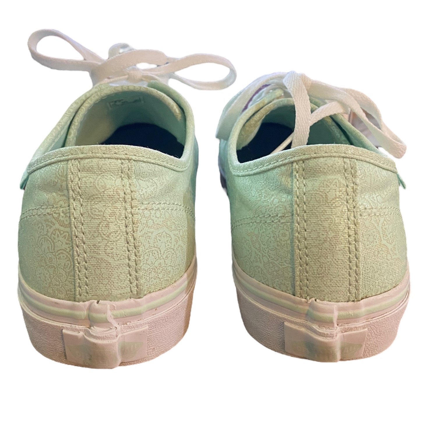Back of a Pair of light green sneakers with white laces on a white background