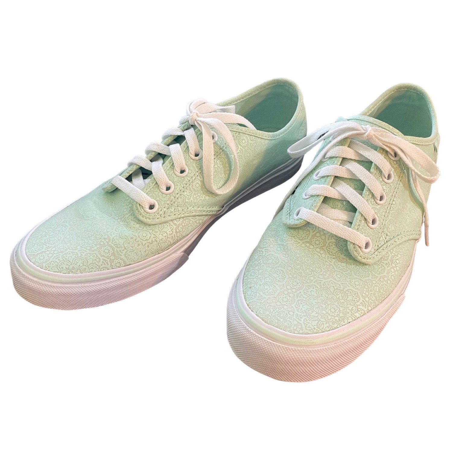 Front side of Pair of light green sneakers with white laces on a white background