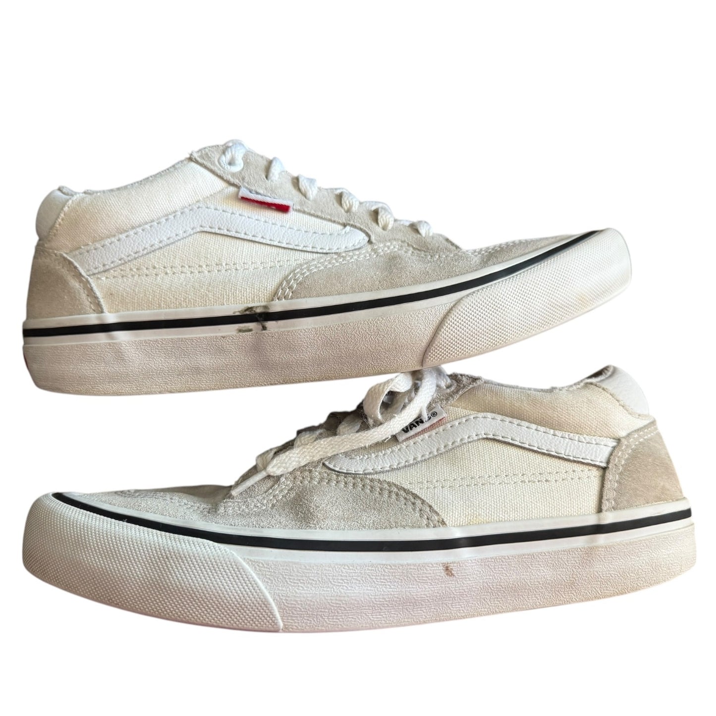 Side of white sneakers on their side with black marks on a white background