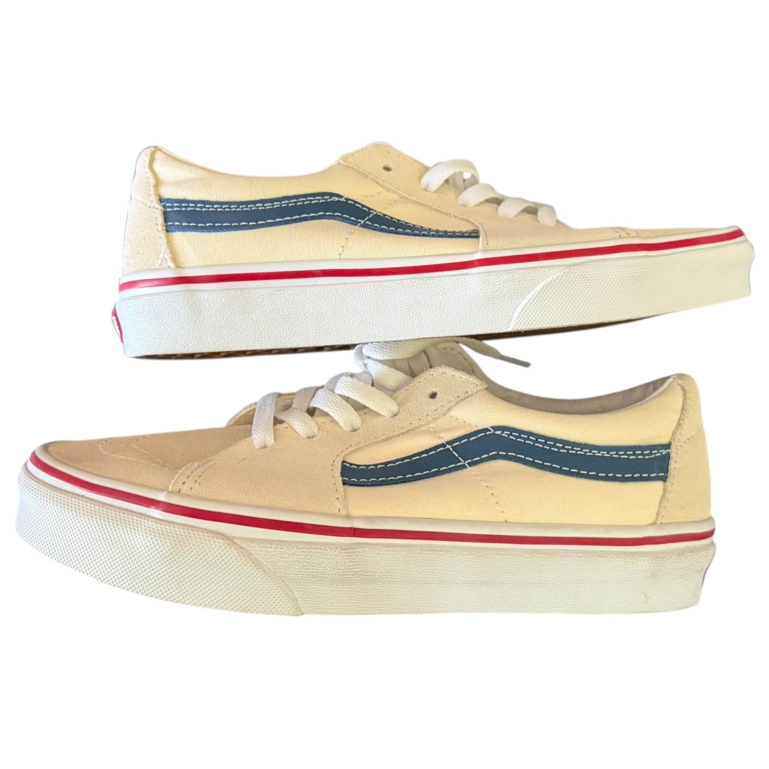 Side of cream sneakers with blue and red accents on a white background