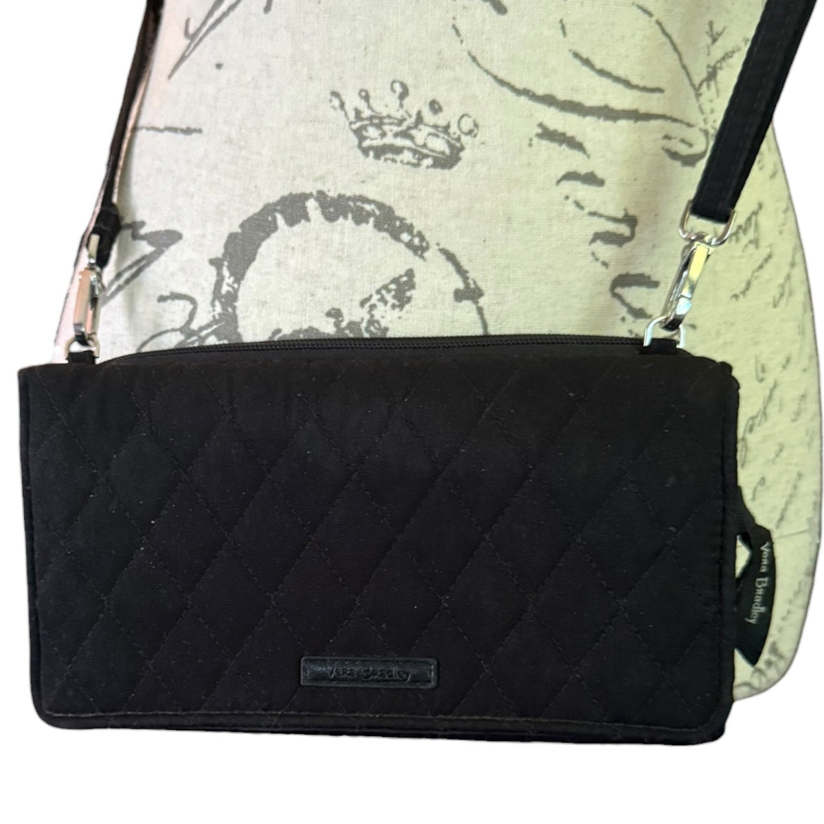 Front of black quilted purse on a mannequin on a white background. 