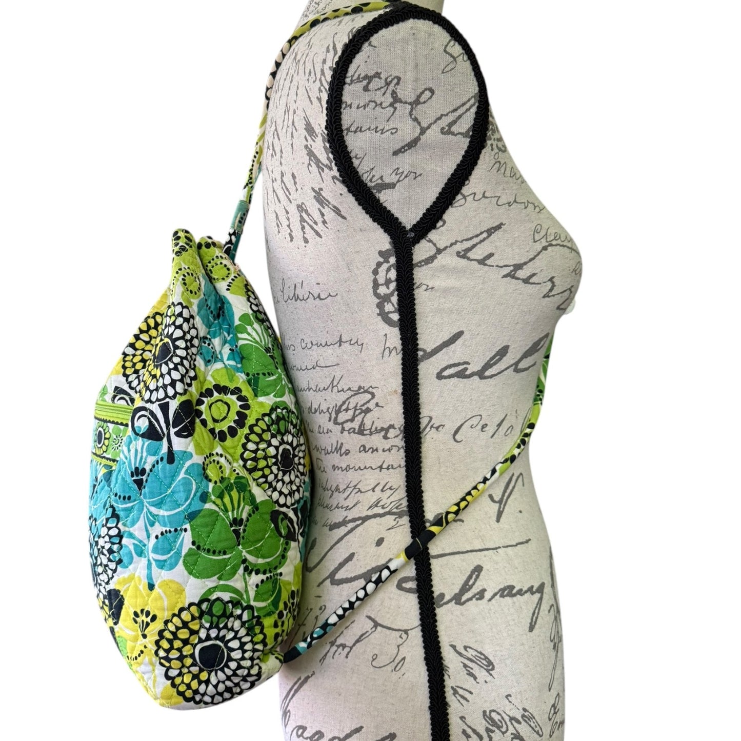 Side view of Floral-patterned pouch and white garment with black text on a white background