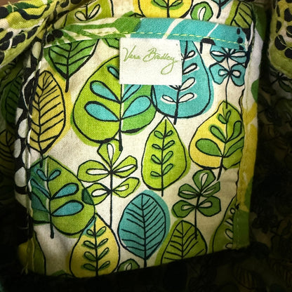 Fabric with leaf pattern and a visible brand label on a dark background