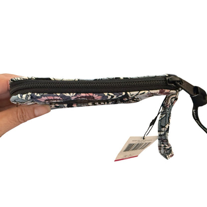 Top of Floral-patterned pouch wristlet with a strap held by a hand on a white background