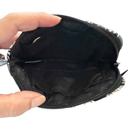 Black interior of wristlet held open by a hand on a white background