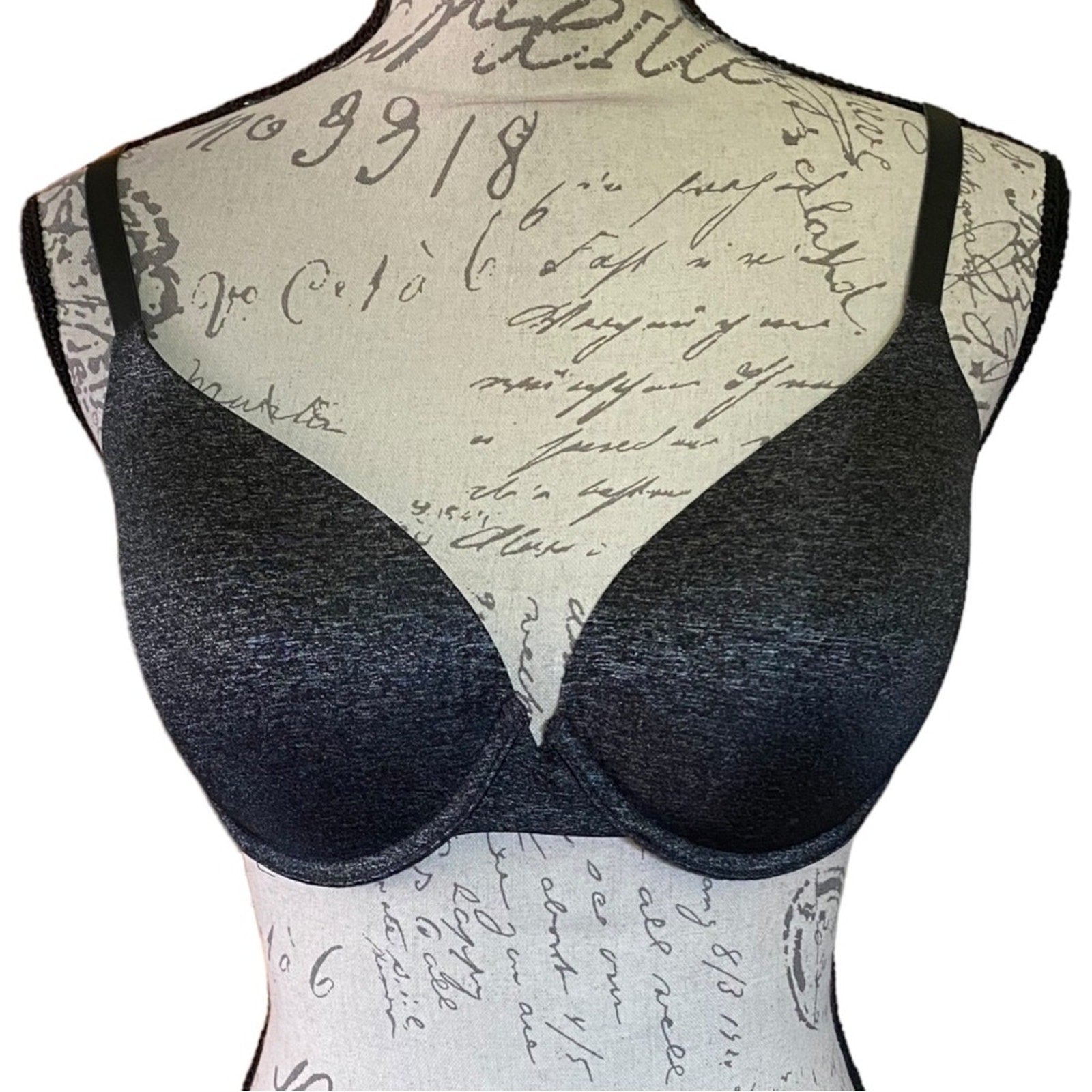 Black bra on a mannequin with a vintage-style script background