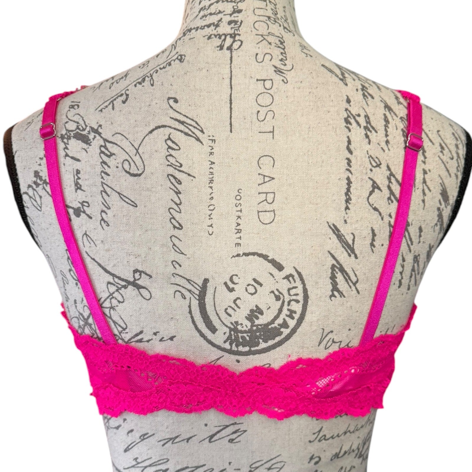 Back of Hot pink bralette on a mannequin with a vintage-style background