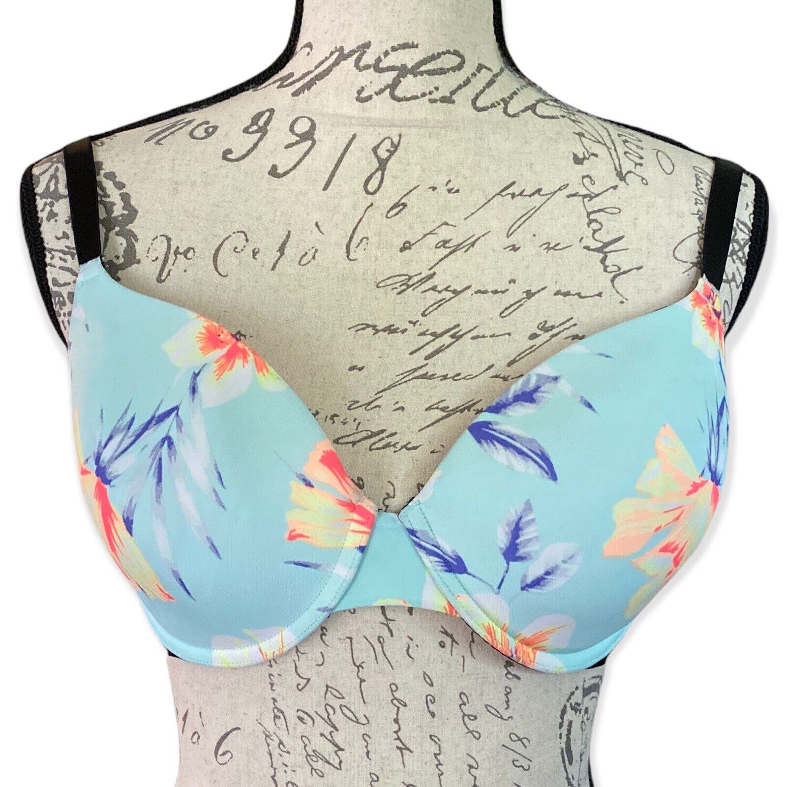 Front of Floral-patterned bra on a mannequin with a script background