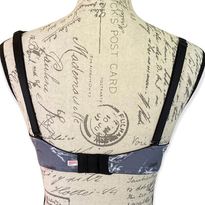 Back of gray bra on a mannequin with vintage-style text and stamp design