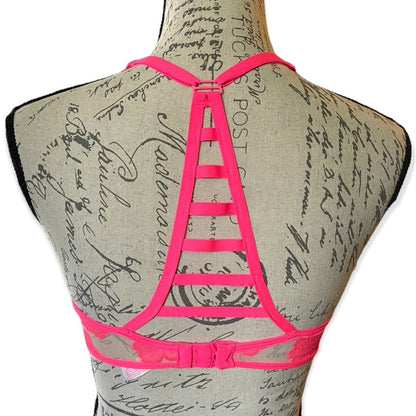 Pink strappy bra on a mannequin with a vintage-style script background