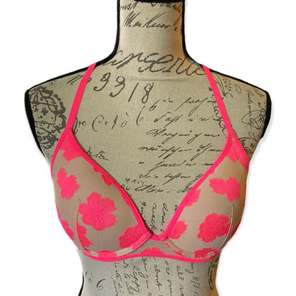 Bra with pink floral design on a mannequin with script text background