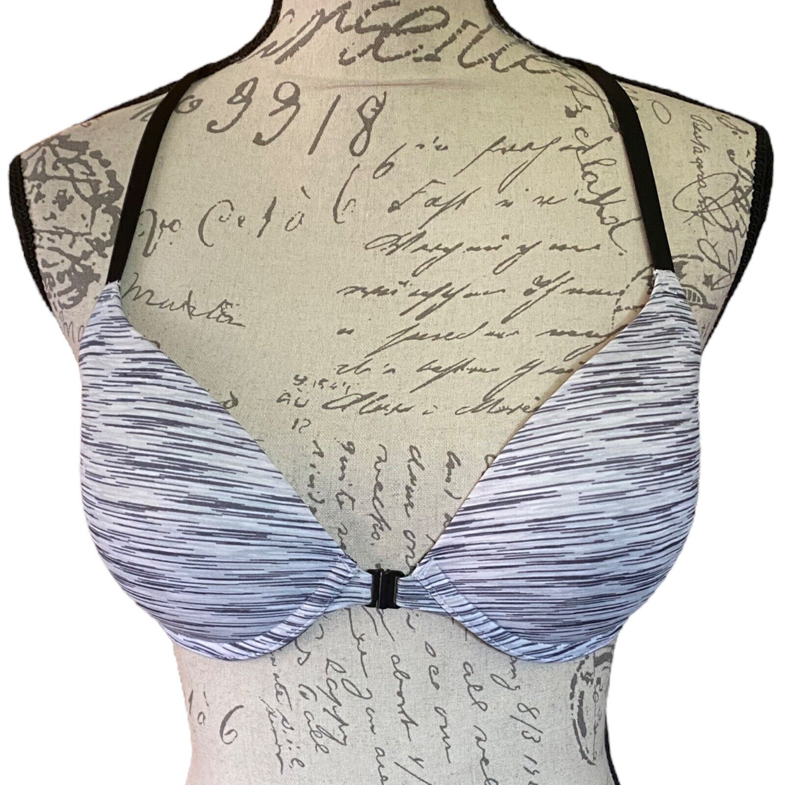 Black & white bra on a mannequin with a vintage letter background