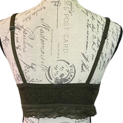 An green lace bralette displayed on a vintage-style printed dress form mannequin, showing the back view with shoulder straps and a lace underband.
