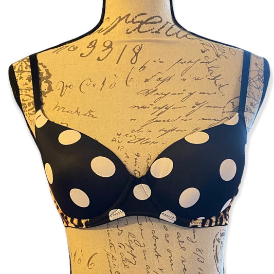 Black bra with white polka dots on a mannequin with vintage script background