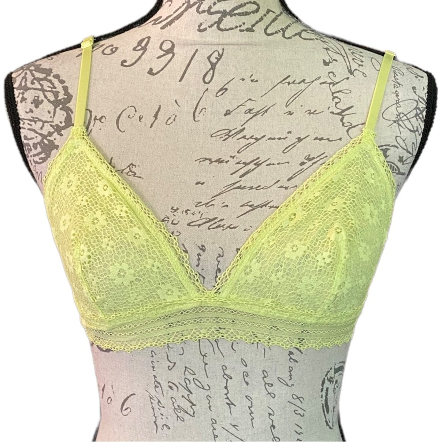 Yellow lace bra on a mannequin with a script background