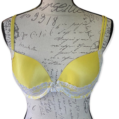 Front of Yellow bra on a mannequin with a script patterned background