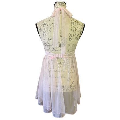 A sleeveless babydoll-style lingerie dress displayed on a mannequin, featuring a cream-colored printed bodice with cursive script, a light pink ribbon belt at the waist, and a sheer white tulle skirt.