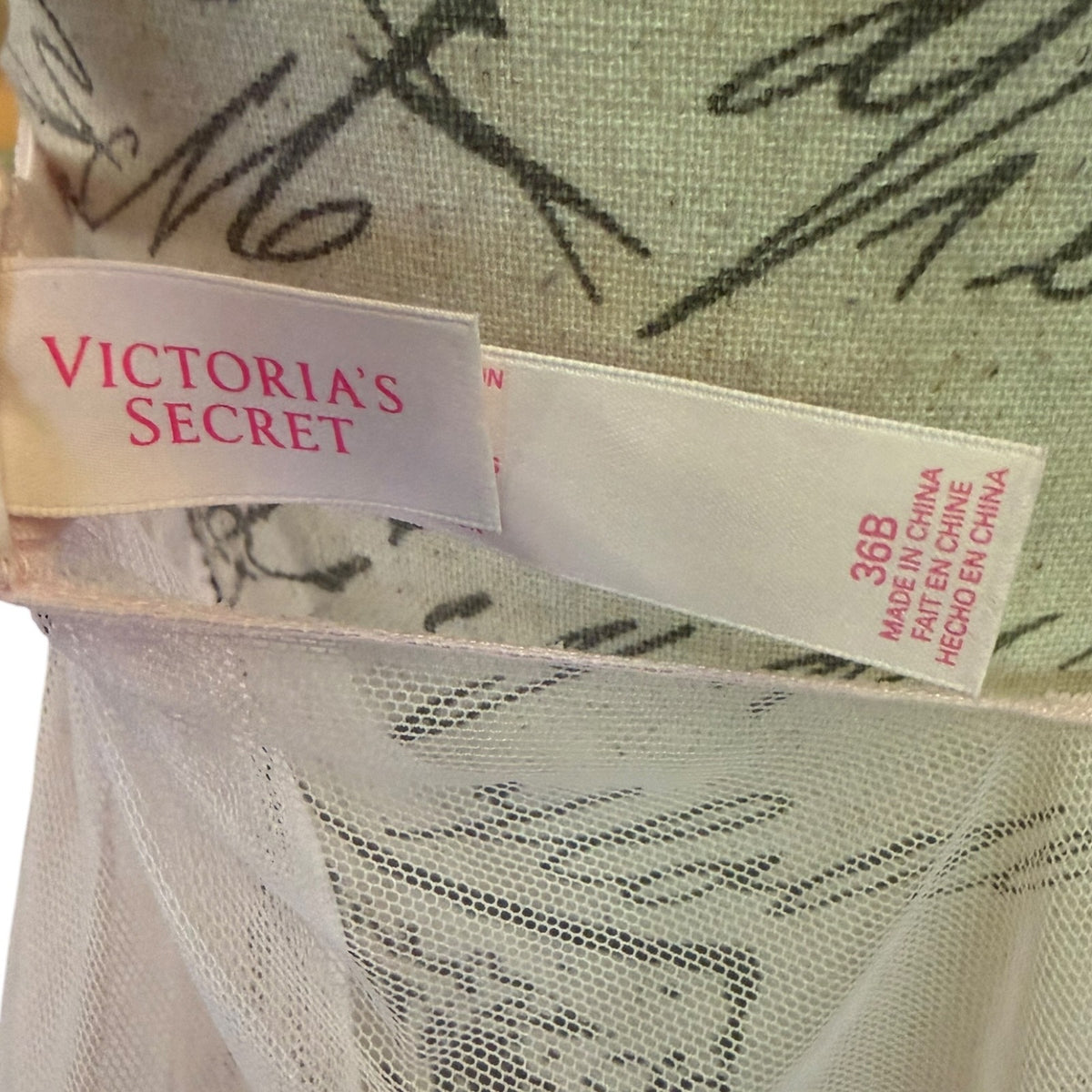 Close-up of a Victoria's Secret garment tag on a light pink fabric 