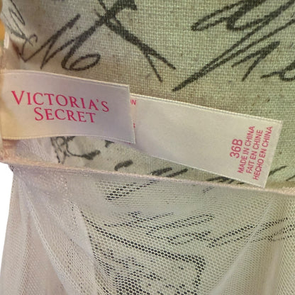 Close-up of a Victoria's Secret garment tag on a light pink fabric 