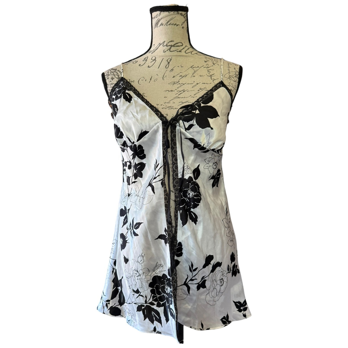 A sleeveless black and white floral print babydoll displayed on a vintage-style dress form mannequin against a plain white background.