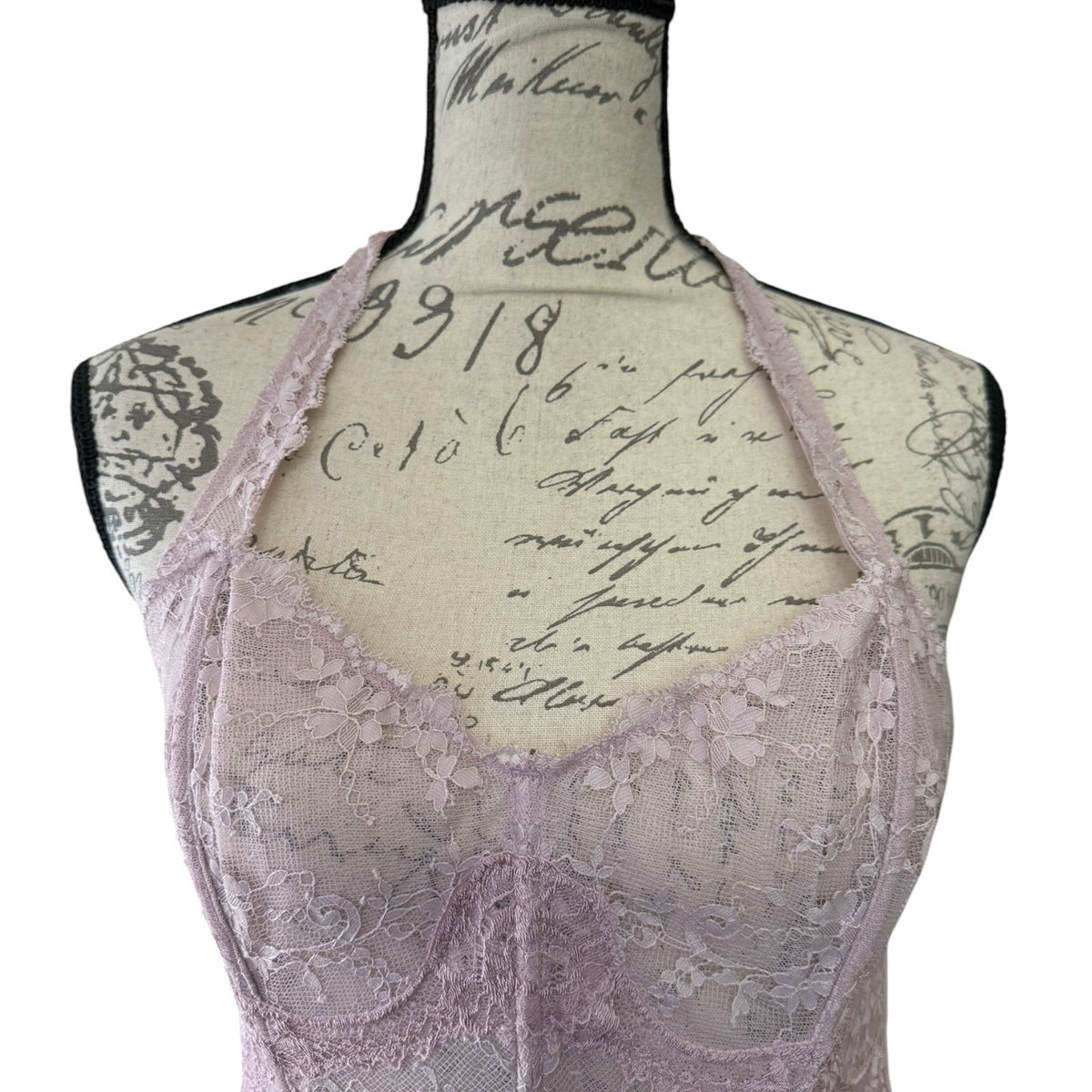 Lace bustier bra top on a mannequin with vintage-style text background