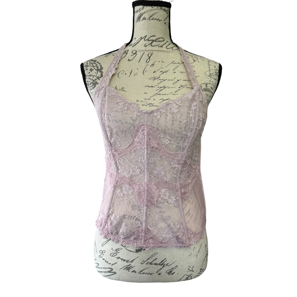 Lace bustier bra top on a mannequin with a vintage-style script background