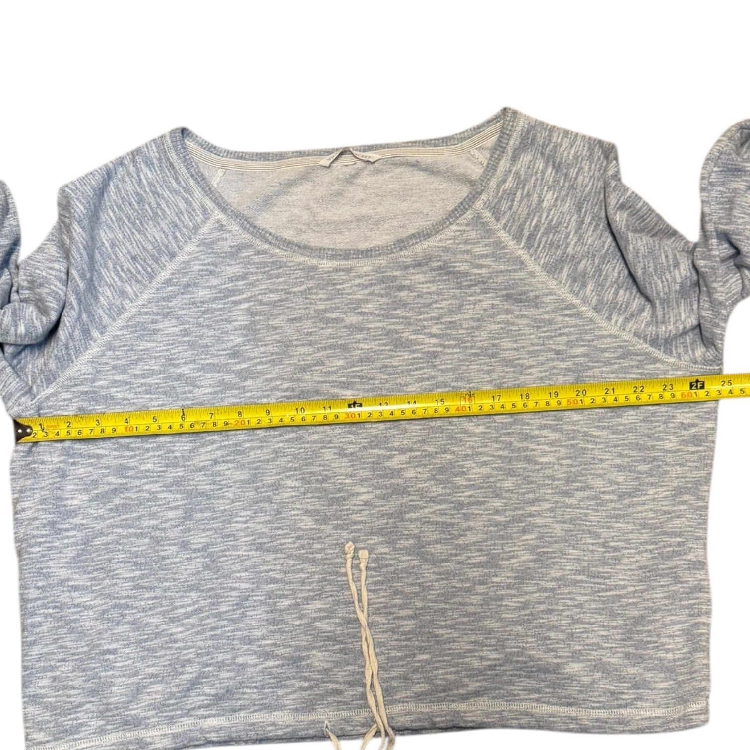 Blue shirt and a measuring tape across it on a white background